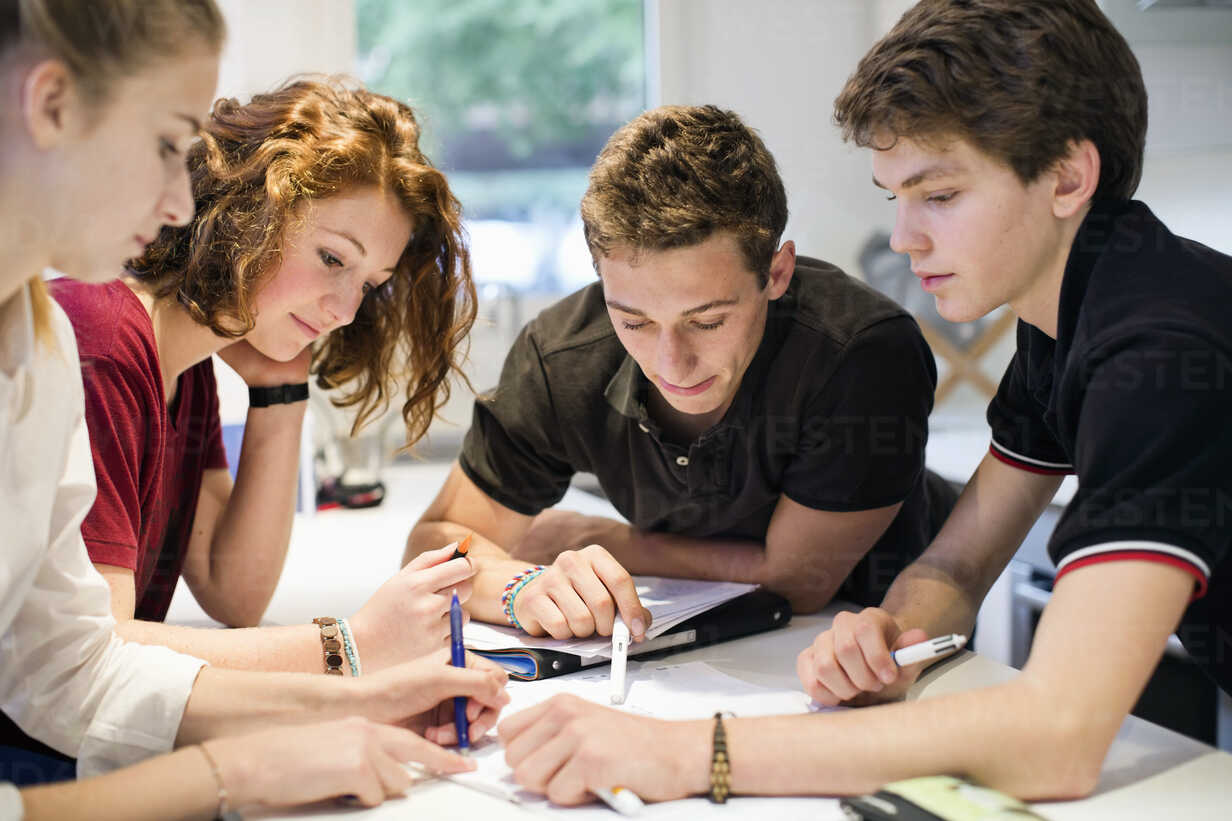 Young students studying together at table