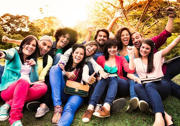 Multi-ethnic group of young students sharing and having fun at a university campus.