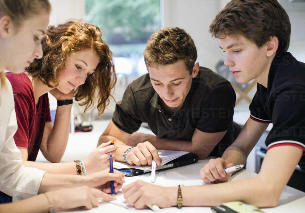 Young students studying together at table