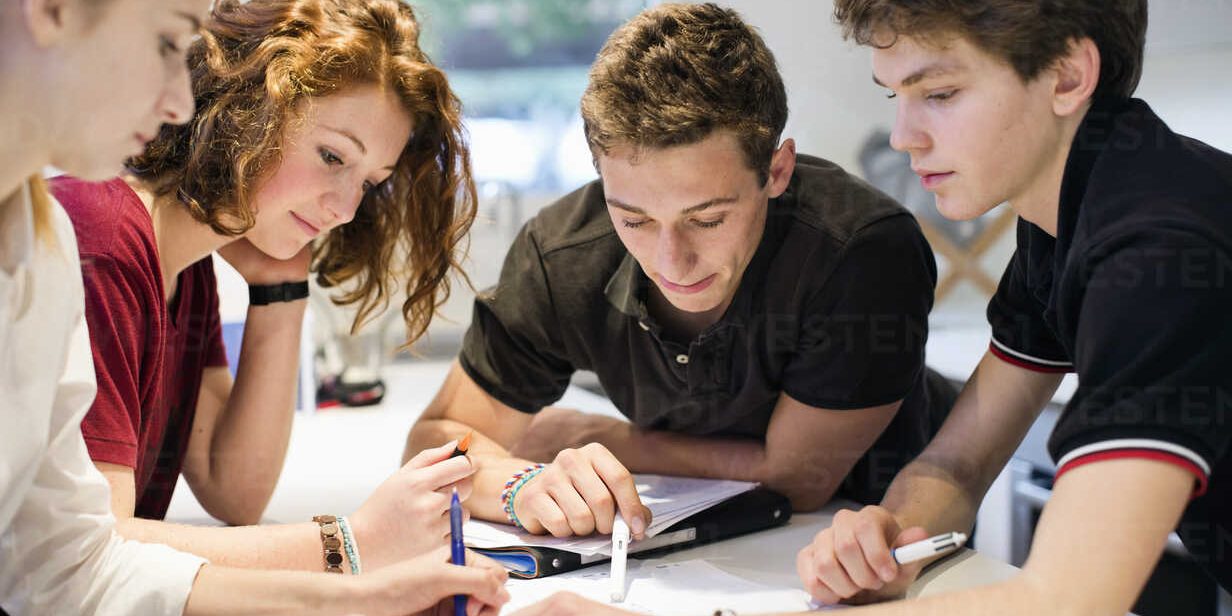 Young students studying together at table